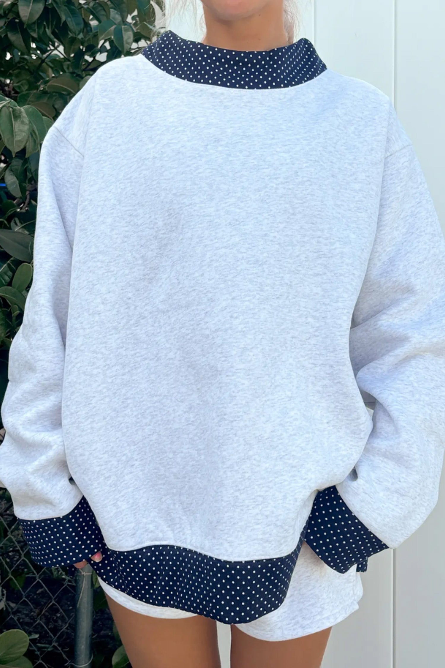 Women's gray sweatshirt with navy polka dot trim at neck, cuffs and hem, front view