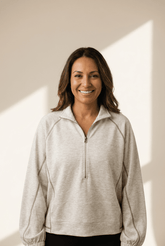 Woman wearing a beige pullover with a neutral background