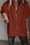 Woman wearing a rust-orange chunky knit sweater with short sleeves and black leather pants.