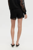 Person wearing black lace-trimmed shorts on a white background