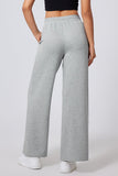Person wearing gray sweatpants on a plain background