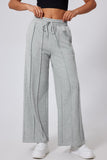 Gray sweatpants worn by a person on a white background