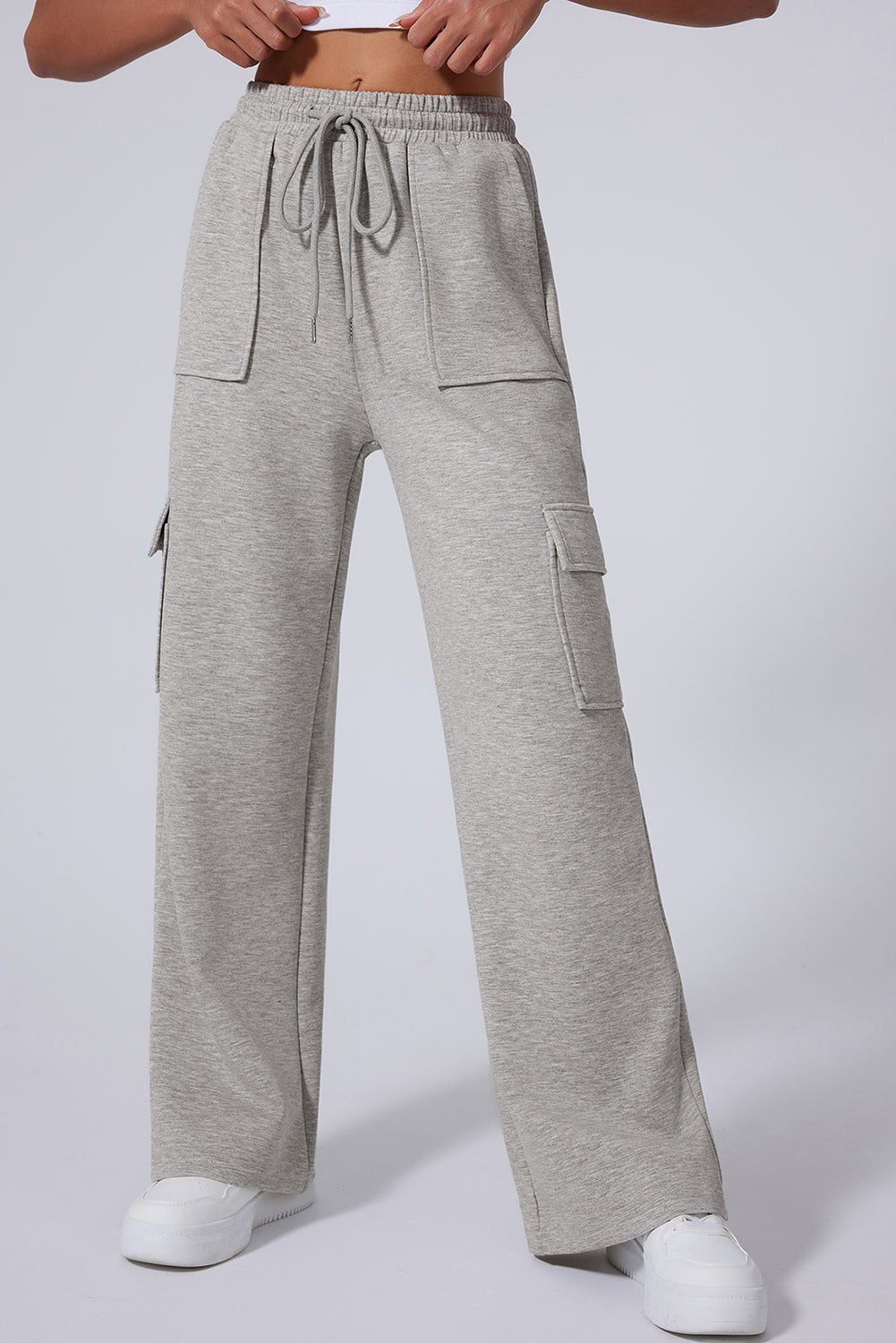 Person in light gray wide-leg cargo sweatpants with drawstring waist and pockets.