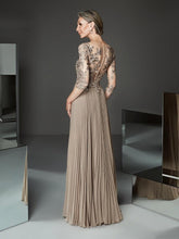 Woman wearing a long, elegant dress with intricate detailing in a modern setting.