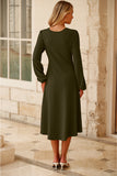 Back view of jungle green midi dress in a sunlit stone corridor