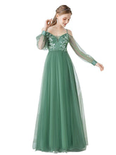 Green evening gown with floral lace details on a white background