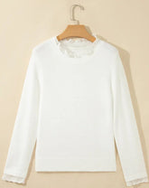 A white long-sleeve knit sweater with delicate lace trim at the crew neckline and cuffs,