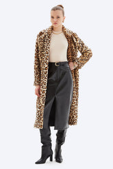 Person wearing a leopard print coat with a plain background
