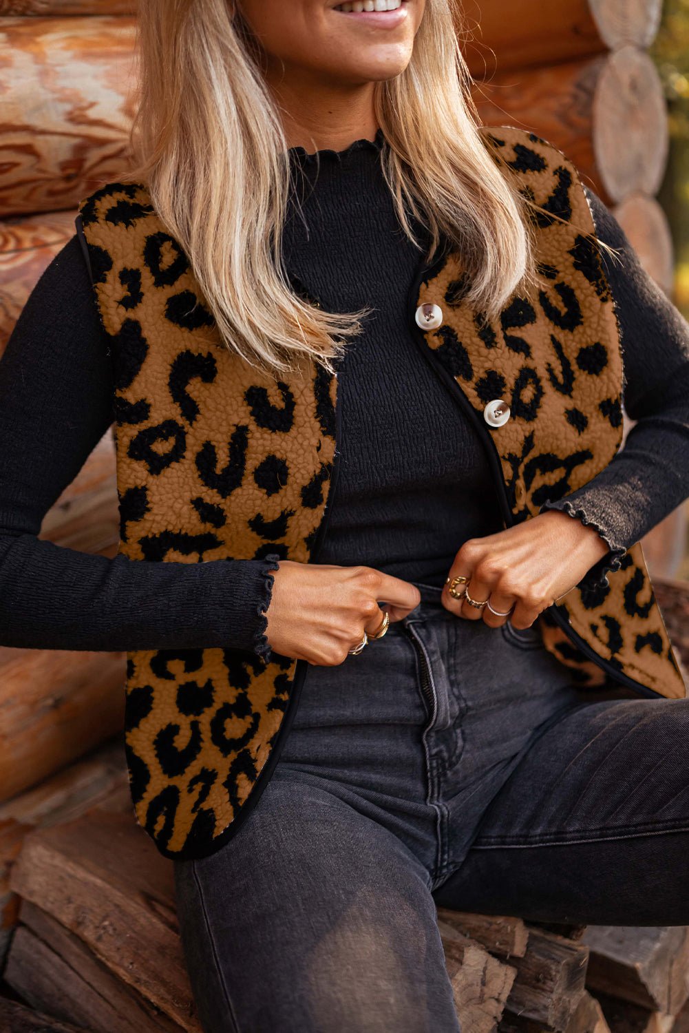 Woman in brown-black leopard faux-fur vest, black top, and dark gray jeans.