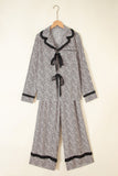 Black-and-white floral pajama set with ruffled trim and wide-leg pants.