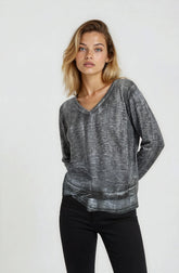 Woman wearing a gray sweater and black pants on a white background