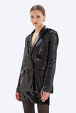 Woman wearing a black sequin blazer on a white background