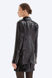 Woman wearing a black sequin jacket on a white background