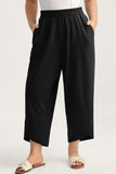 Person wearing black wide-leg pants on a white background