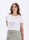 Woman wearing a white t-shirt with a graphic design on a plain background