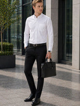 Man in formal attire holding a briefcase outside a building
