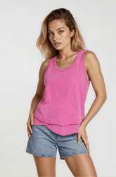 Woman wearing a pink tank top and denim shorts on a white background
