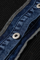 Close-up of dark blue denim button panel with silver snaps and gray stitching, bordered by black ribbed knit fabric.