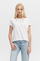 Person wearing a plain white t-shirt and light blue jeans on a white background