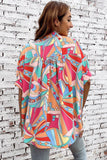 Woman wearing a colorful patterned shirt against a white brick wall.