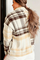 Woman wearing a plaid jacket with a neutral background