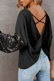 Black ribbed top with criss-cross back design and sequin sleeves worn by a person against a neutral background.