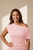 Woman wearing a pink off-shoulder dress against a neutral background