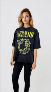 Woman wearing a black t-shirt with yellow 'Mermaid' text and graphic on a white background