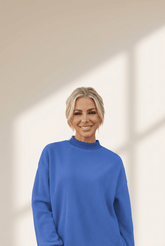 Woman wearing a blue sweater against a neutral background
