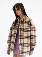 Woman wearing a plaid shirt over a purple dress on a white background