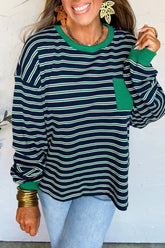 Woman wearing a green and navy striped sweater with a white background