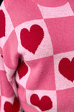 Close-up of red heart and pink checkerboard knit on Valentine sweater