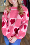 Pink heart checkered Valentine sweater with balloon sleeves, worn with blue jeans