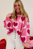 Woman in pink checkered heart crew neck sweater with white jeans for Valentine's Day