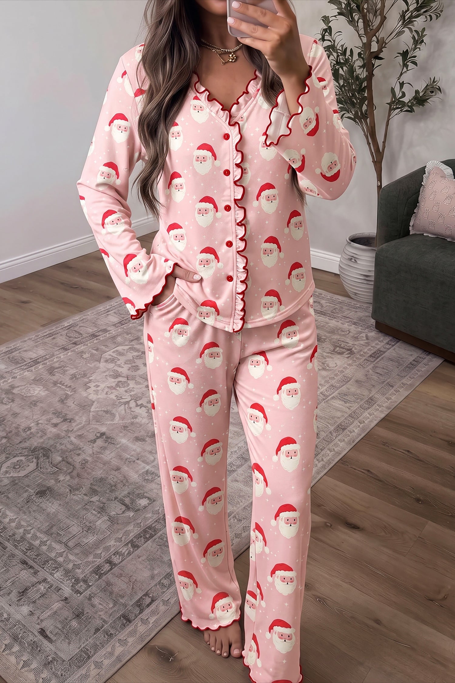 Woman wearing pink Santa print ruffle trim button front Christmas pajama set, front view