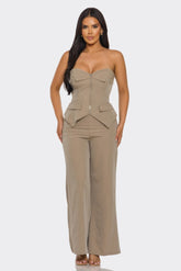 Woman wearing a beige strapless jumpsuit on a white background