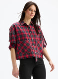 Woman wearing a red and black plaid shirt on a white background