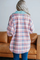 Person wearing a plaid shirt in a living room setting