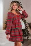 Woman wearing a red plaid dress in a festive indoor setting with Christmas decorations.