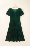 Dark green velvet tiered V-neck dress with short sleeves on hanger.