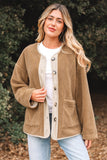 Woman wearing a brown cardigan with a white shirt and light blue jeans, standing outdoors.