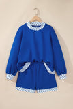 Royal blue lounge set with sweatshirt and shorts, featuring white-blue polka-dot trim on a wooden hanger.