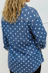 A woman wearing a blue denim shirt with a white polka dot pattern, shown from the back.