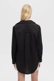 Person wearing a black shirt with a plain background