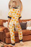 Woman viewed from behind in pumpkin-print pajamas with polka dot trim.