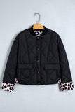 Black quilted puffer jacket with leopard cuffs on a hanger, front view