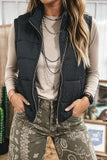 Women's black quilted stand collar puffer vest with printed jeans, front view