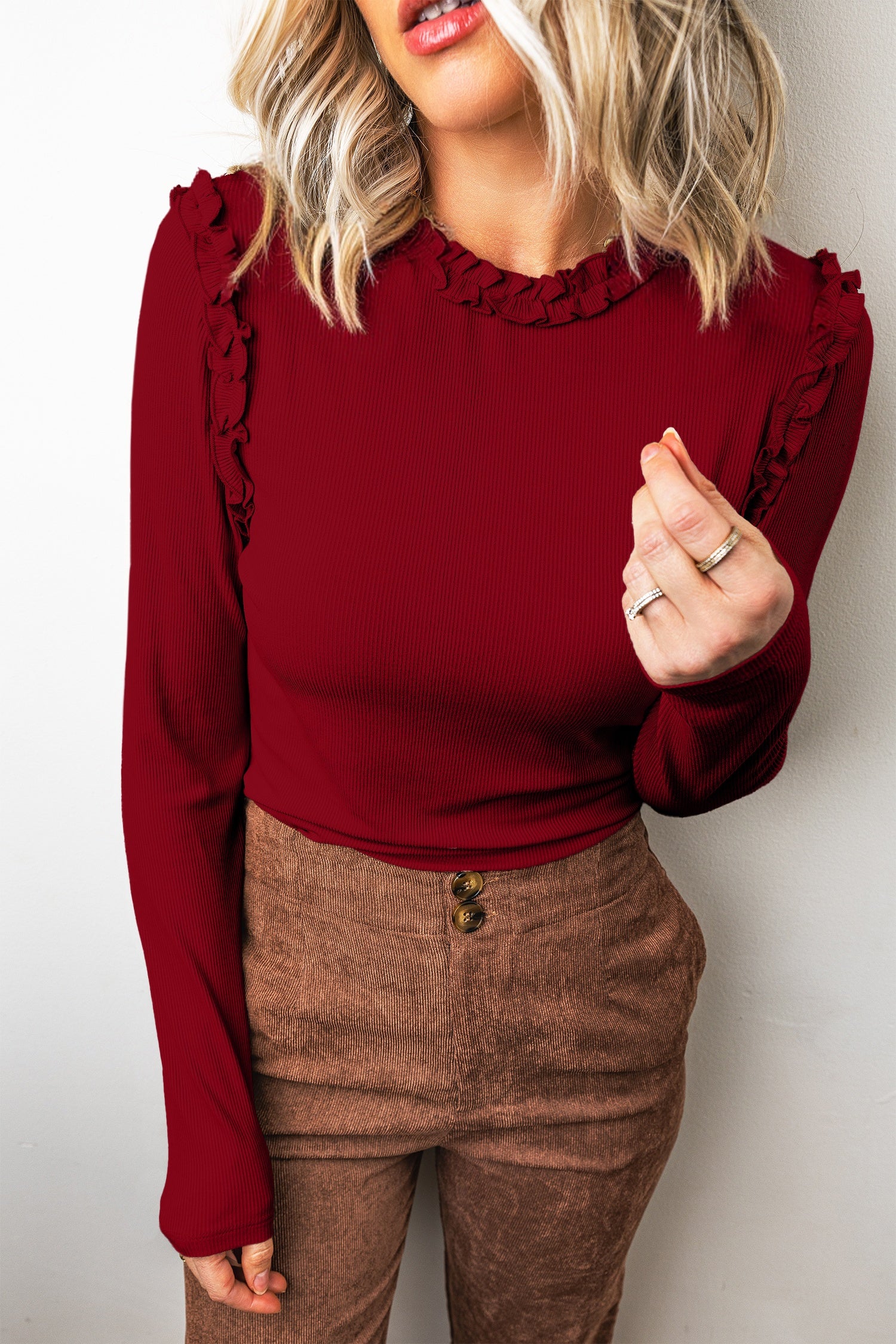 Red dahlia ribbed long sleeve top with frill trim neckline, worn with brown corduroy pants