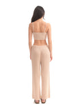 Woman wearing a beige ribbed two-piece set on a white background
