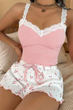 Woman wearing a pink top and white floral shorts with lace details.